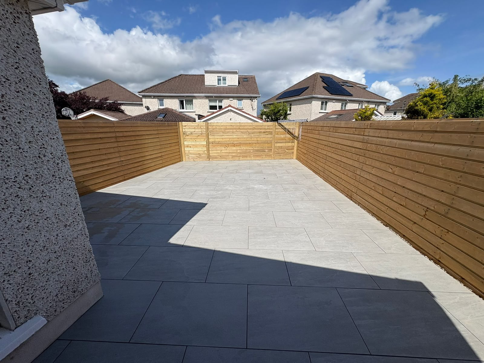 Completed large-format grey porcelain patio with new timber fencing in Dublin