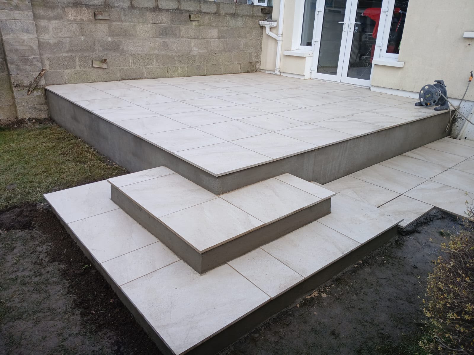 Raised cream porcelain patio with tiled steps at a Dublin family home